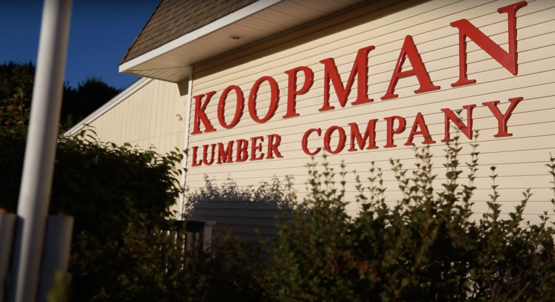 Exterior view of Koopman Lumber Company building with visible signage in bold red letters.