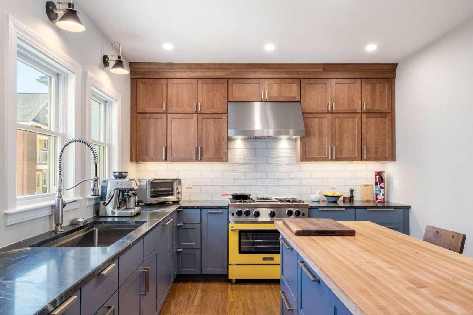 This image depicts a kitchen showcasing wooden and blue full overlay cabinets for a sleek look.