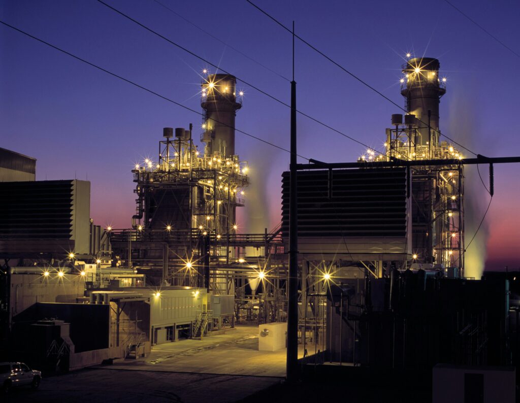 This image depicts a gas power station with large turbines and infrastructure, generating electricity for industrial use.