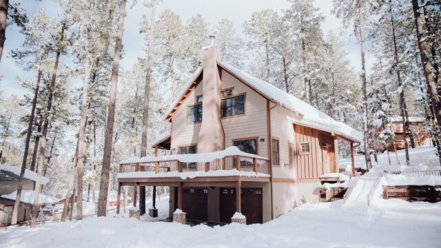 This image depicts a three-story house in a showy landscape.