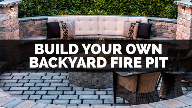 Outdoor patio with a circular fire pit, cushioned seating, and decorative pillows against a backdrop of greenery.