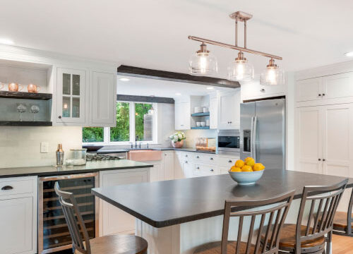 Modern kitchen interior with island, bar stools, and stainless steel appliances.