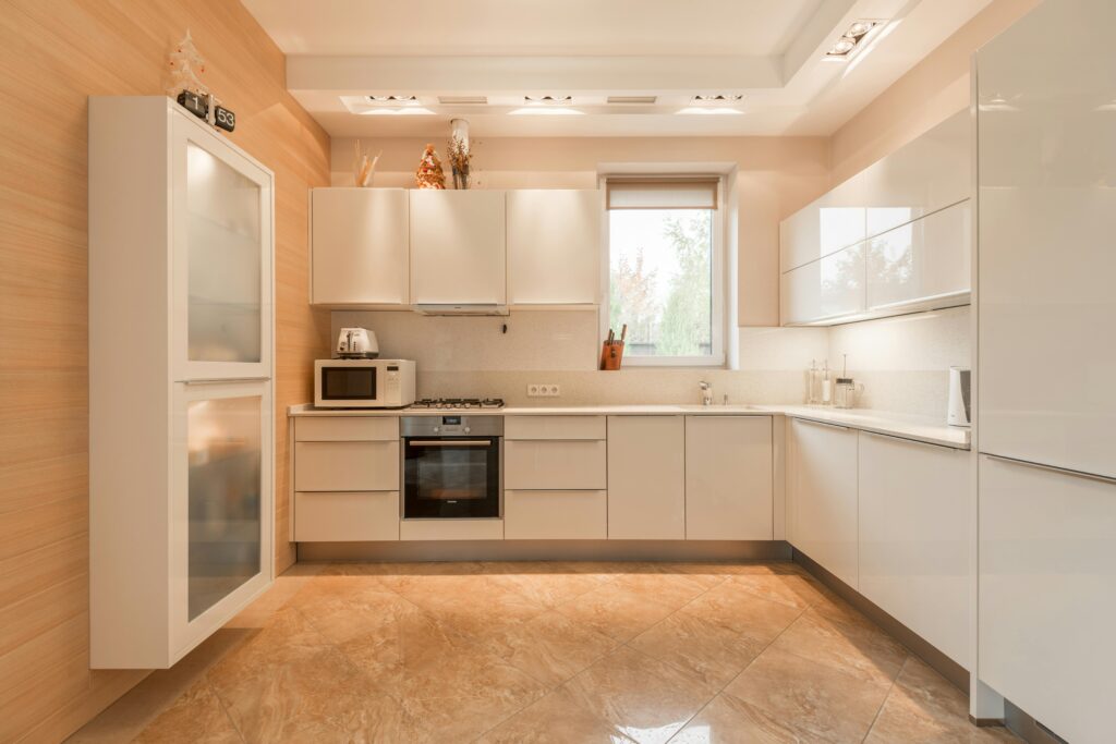 A minimalist modern kitchen has glossy overhead cabinets above the kitchen counters.