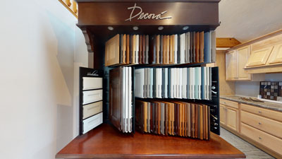 Wood and laminate sample display in a kitchen showroom with various finishes and colors.