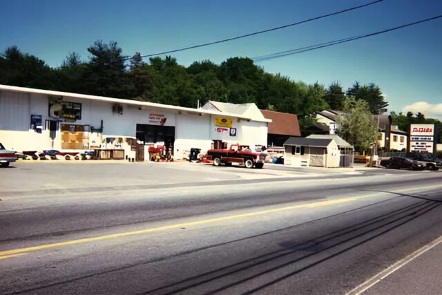Street view of a roadside vintage shop with items displayed outside and a red pickup truck parked in front.