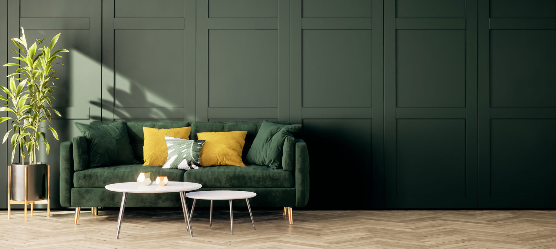 Green velvet sofa with yellow and green cushions against a dark paneled wall, with a nested coffee table in front.