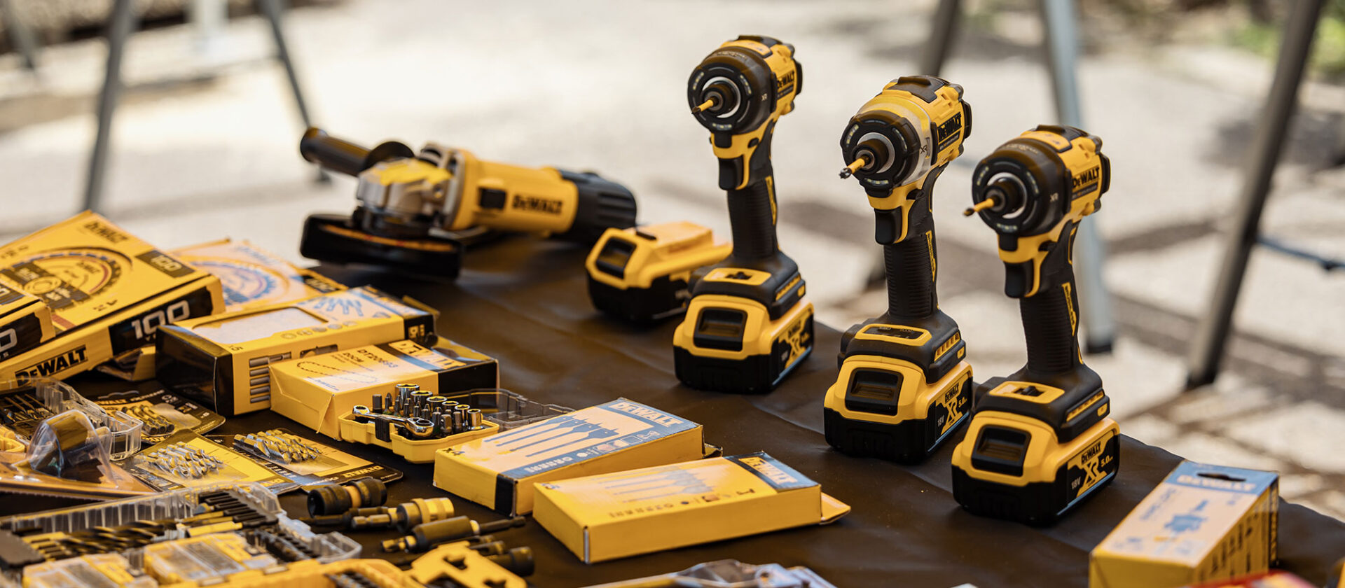 Yellow and black power drills and tools on a table, showcasing a range of hardware equipment for construction or repair work.